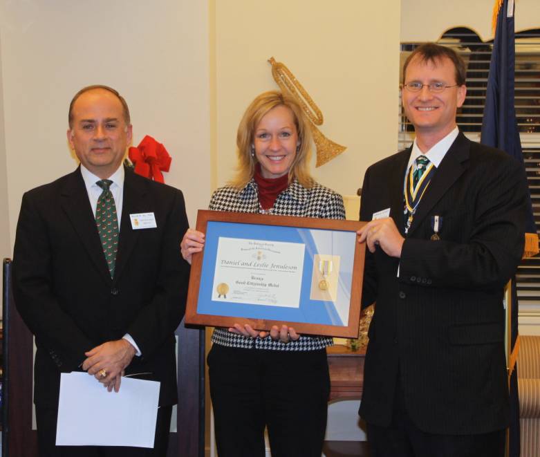 Leslie Jenuleson accepts the award on behalf of the couple from Chairman Bill Price (left) and President Darrin Schmidt