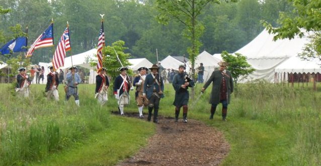 Gen. Joseph Martin (far right) and the Colorguard continue leading the crowd down the path to the monument